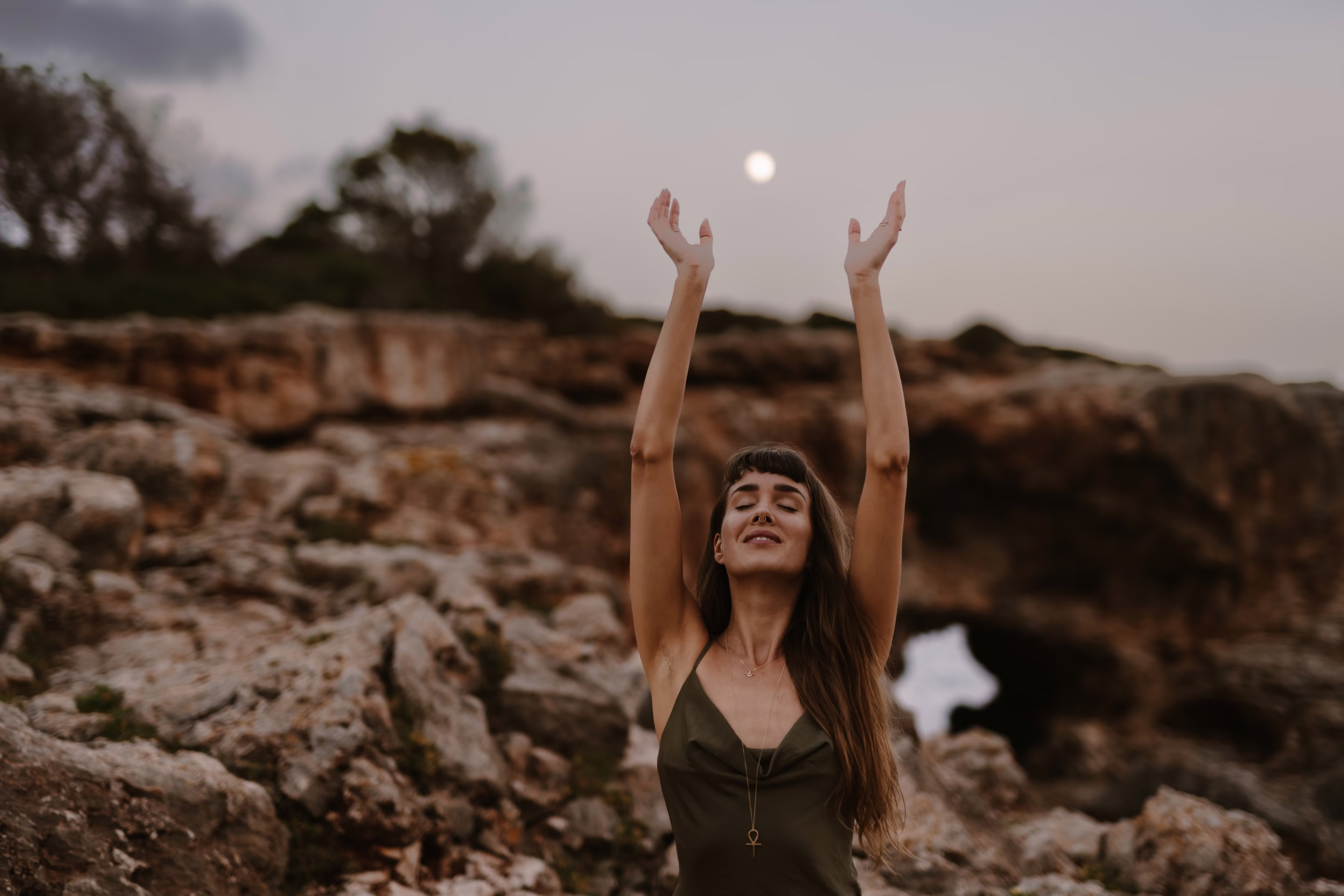 Silja mit erhobenen Armen an der Felsküste, über ihr der Mond